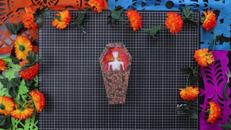pov of person holding small cardboard box with skeleton inside. traditional mexican decoration