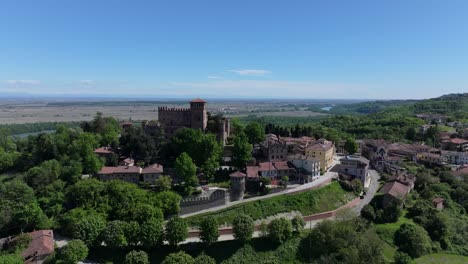 town-reveal-falling-backward-from-lush-green-Gabiano,-Italy,-northern-communal-town-and-must-see-regional-visit