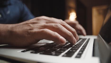 primer plano de las manos del hombre escribiendo en una computadora portátil haciendo oficina en casa