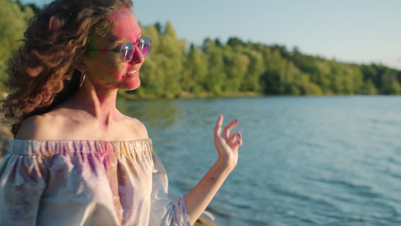 따뜻한 이 있는 날 해변에서 홀리 축제를 즐기며 춤추는 행복한 친구들의  아웃