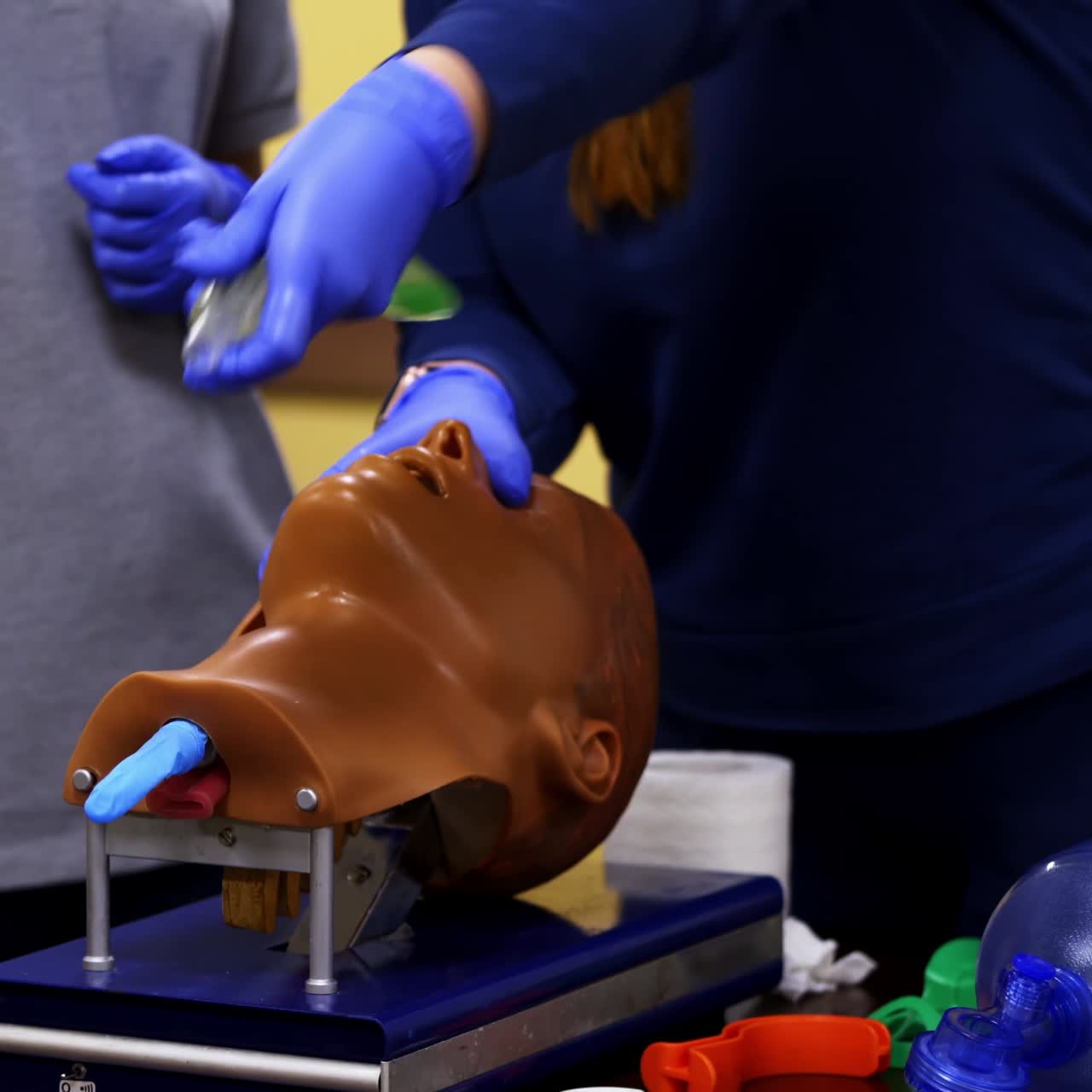 Training session of giving first aid. Person does the training reanimation procedure on a dummy with breathing system.