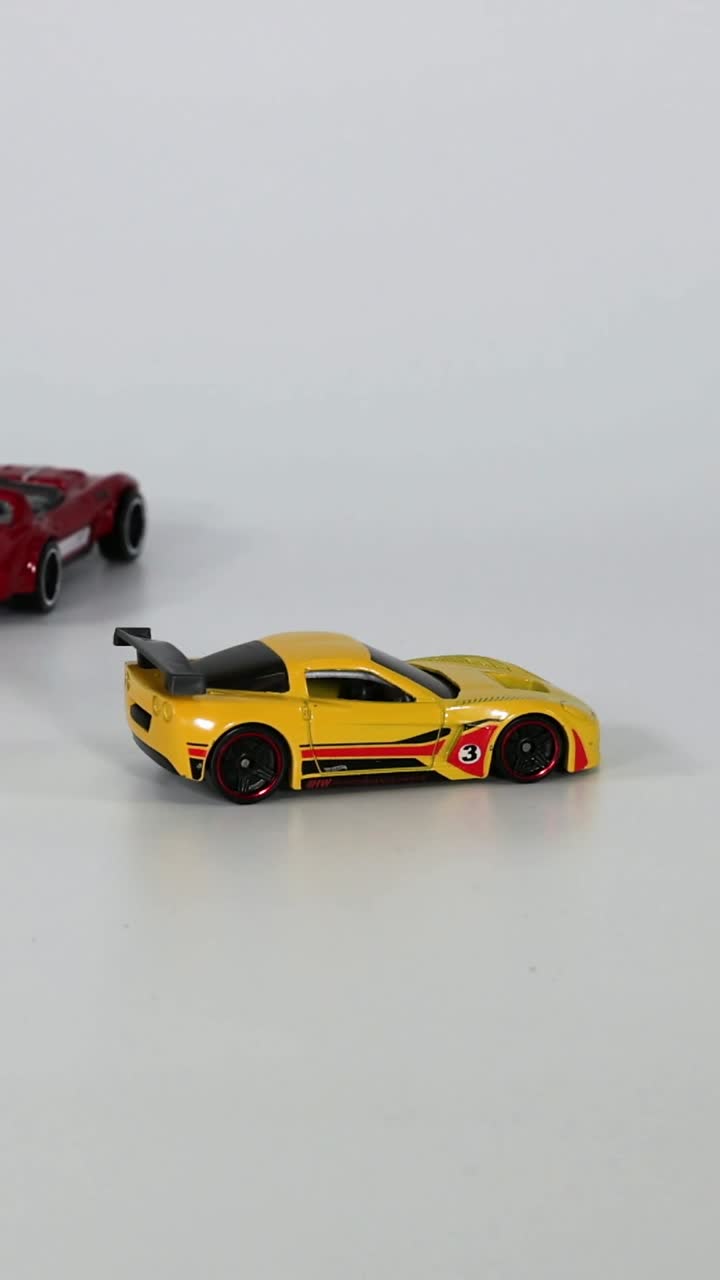 두 개의 장난감 자동차가 트랙에서 만나고 충돌합니다.