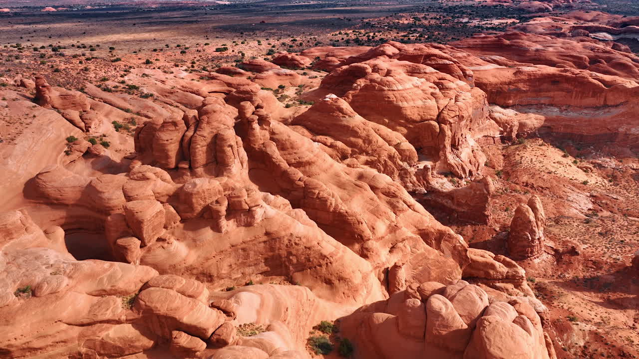 Volo sopra i canyon rossi arrotondati, levigati dal vento e dalla sabbia. Rocce illuminate dal sole nell'Arches National Park, Utah, USA