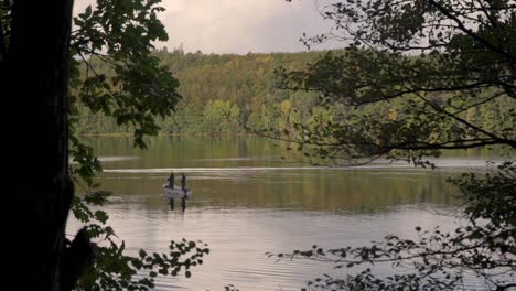 two fishermen on a little boat in a nordic lake