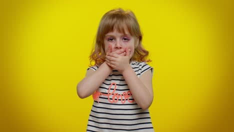 funny little kid child girl closing her mouth with hand refusing to tell terrible secret, truth