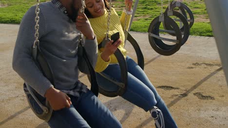 happy couple using mobile phone in the park 4k