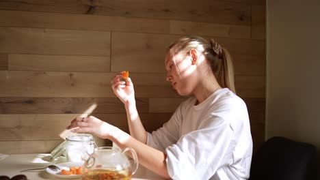 woman eating fruit and drinking tea at home