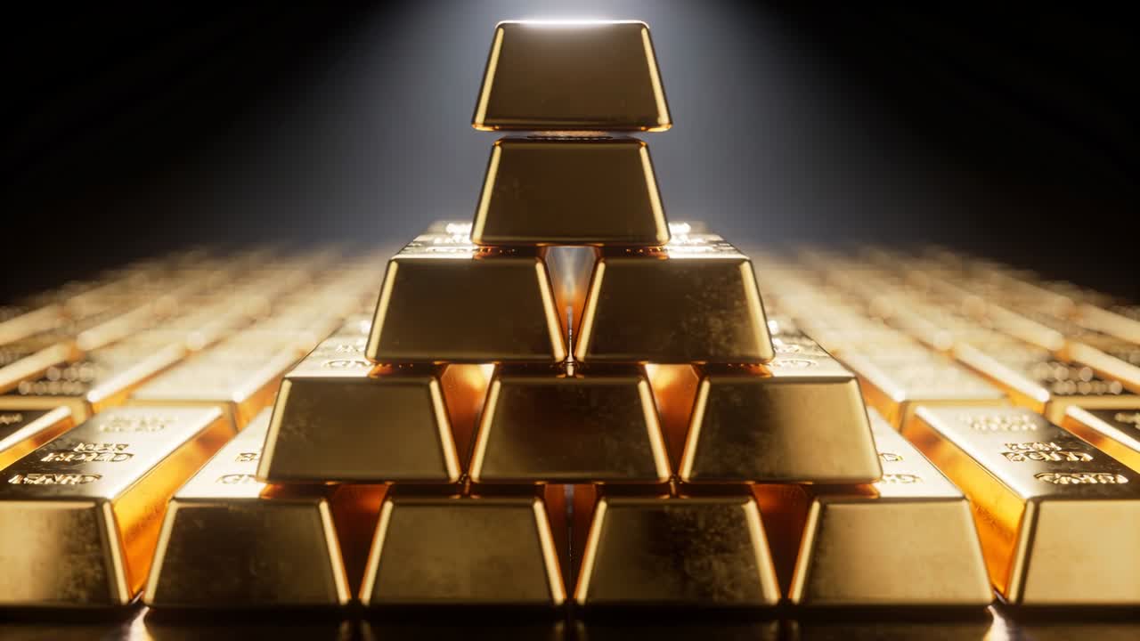 Klesající ruka pokládá poslední zlatý prut na pyramidu na lesklém stole, čímž doplňuje hromadu pod reflektorem