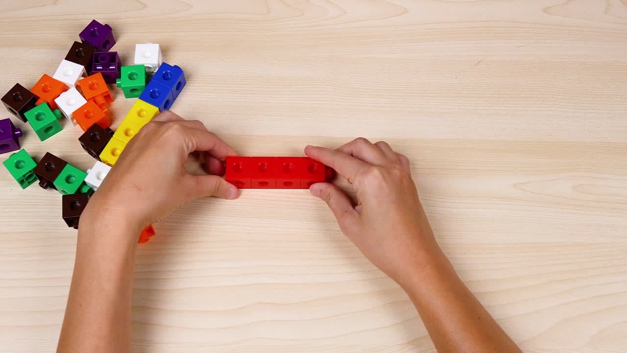 manos montando coloridos cubos de enlace en la mesa
