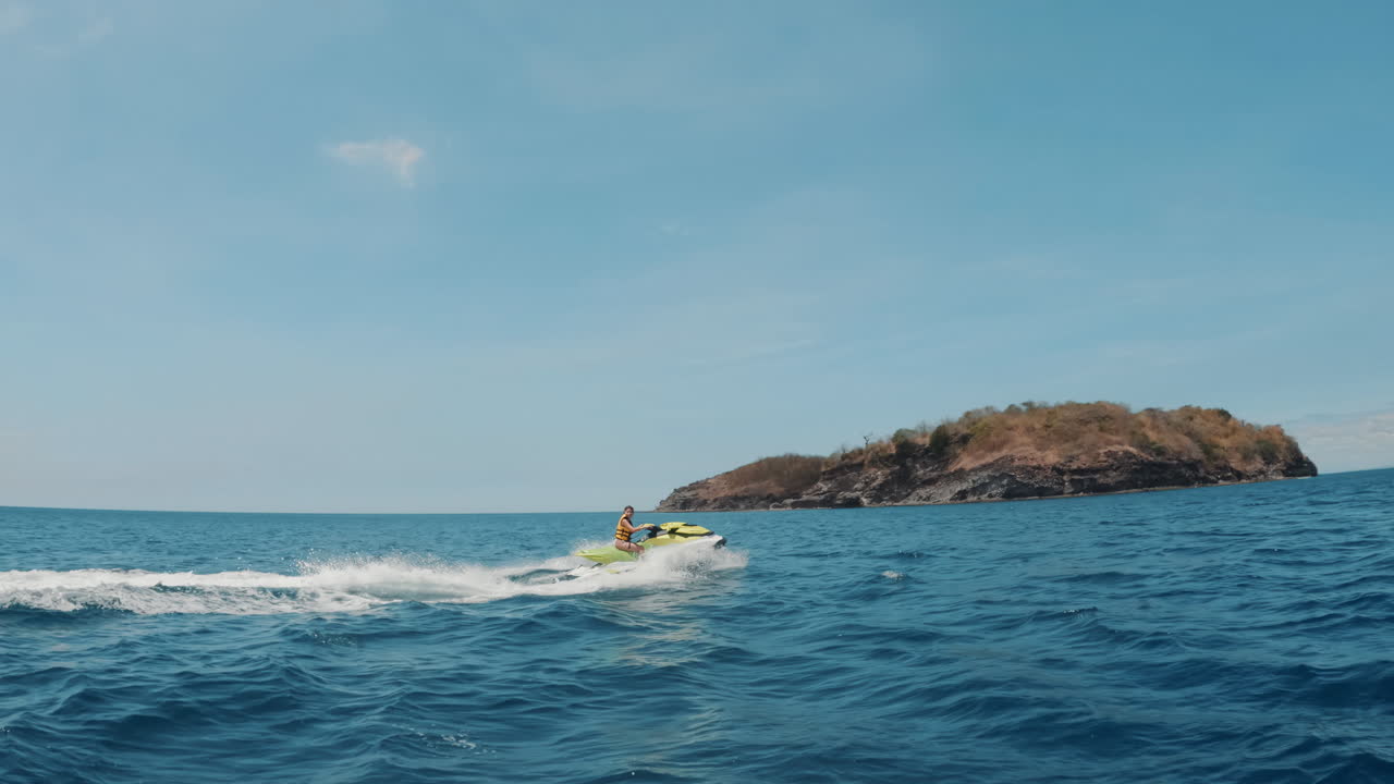 una toma cinematográfica en cámara lenta de un waverunner que atraviesa las olas en el océano azul brillante en un día soleado en filipinas, asia, jet ski, slomo