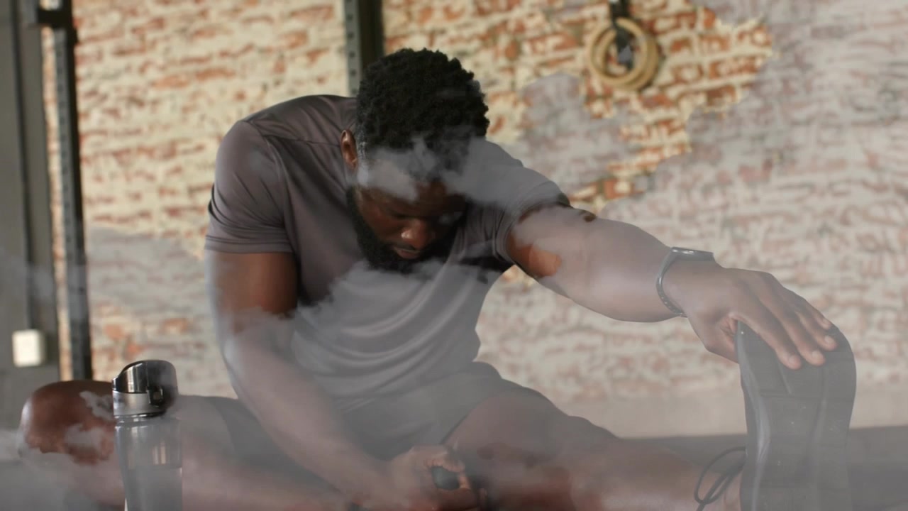 Man bracing on chair after workout, reaching for lap item while fog drifting past bottle