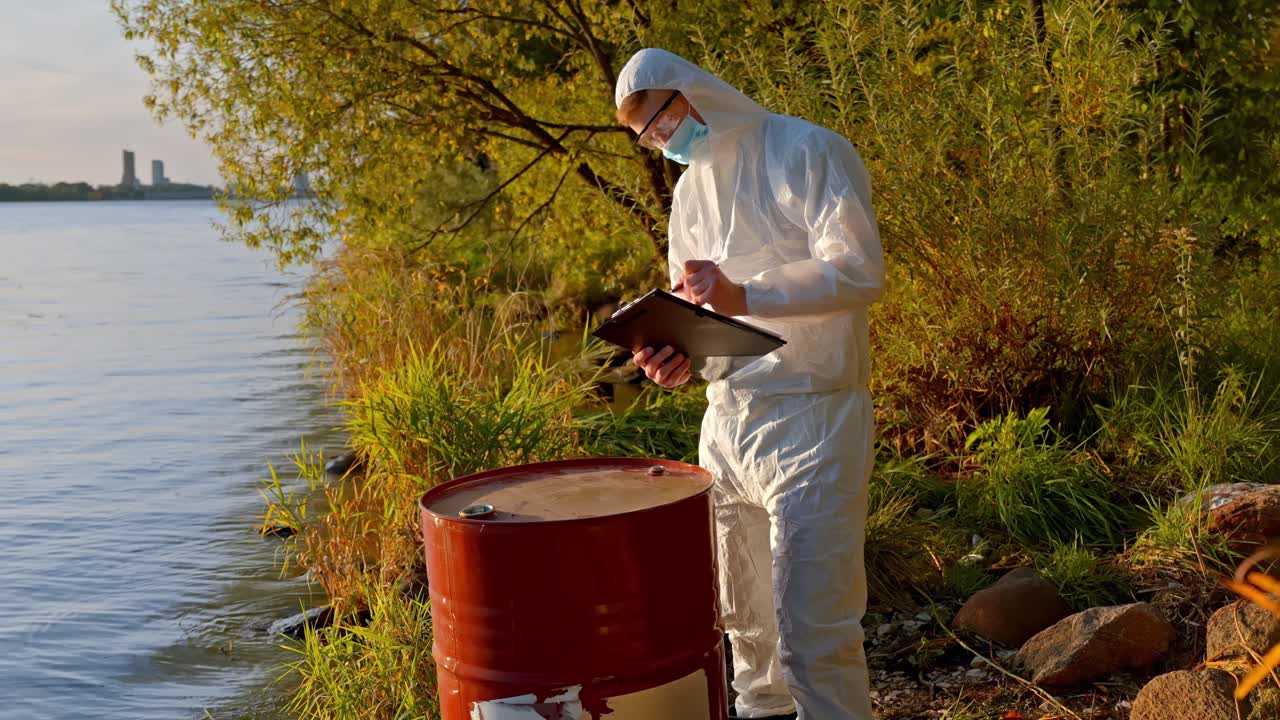 Person in protective gear tests river water for pollution at sunset