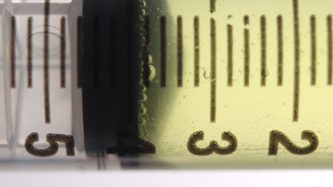 노란색 액체가 통과하는 주사기