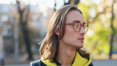 close-up view of a young hipster caucasian man in glasses looking aside