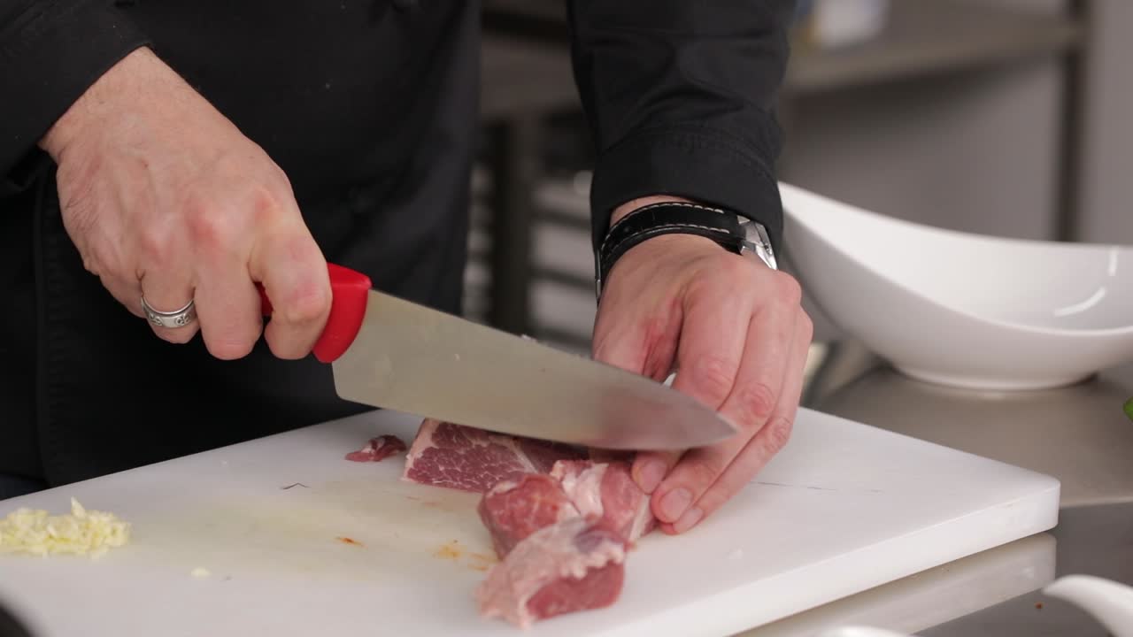 chef cortando carne de cerdo cruda