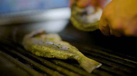 cook grilling fish in kitchen 7