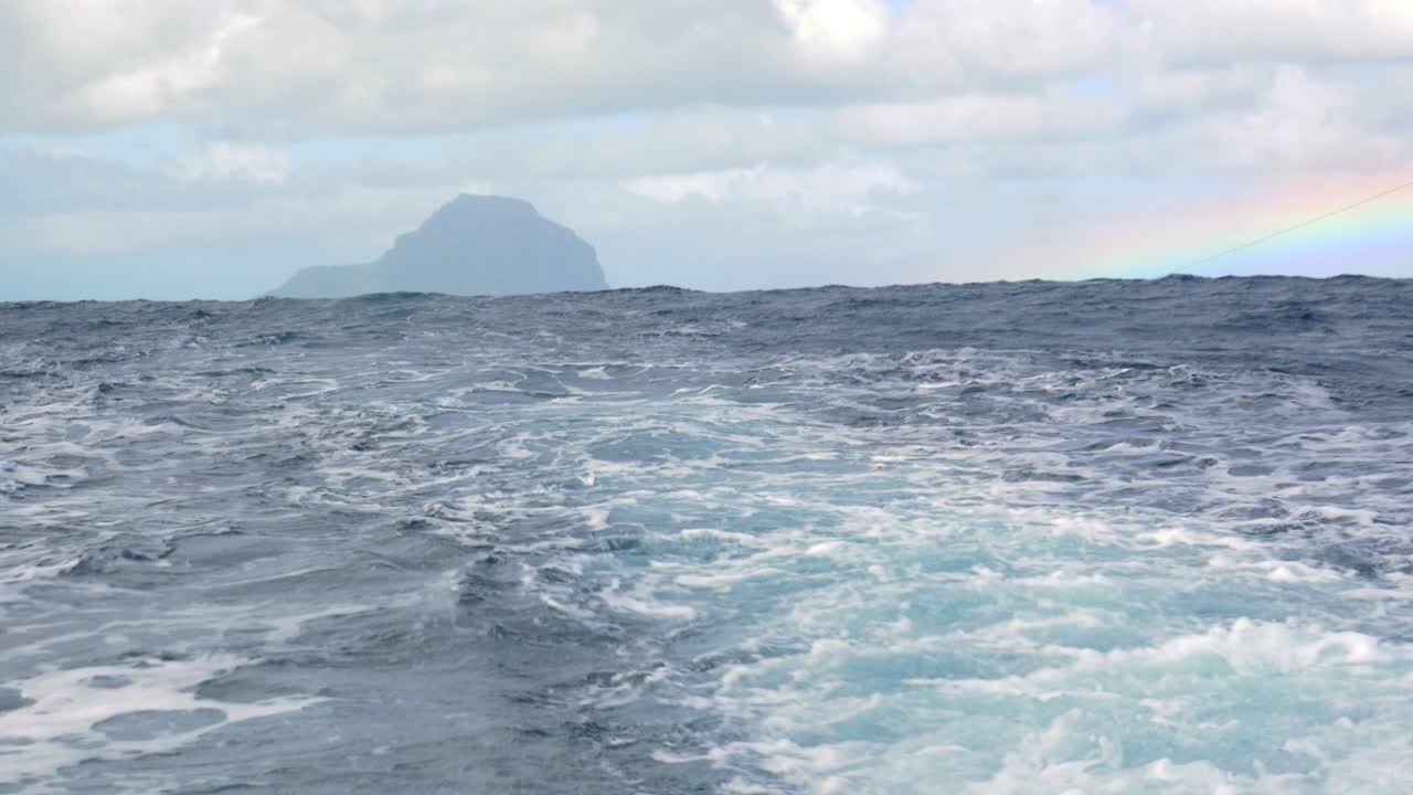 océano ondulado y la vista de la isla lejana desde el barco