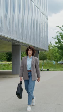 businesswoman walking outside modern building