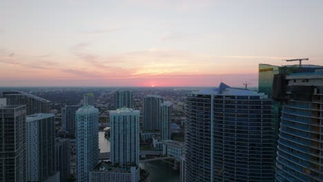 forwards fly above modern urban borough. tall residential downtown buildings and romantic colourful sunset sky. miami, usa