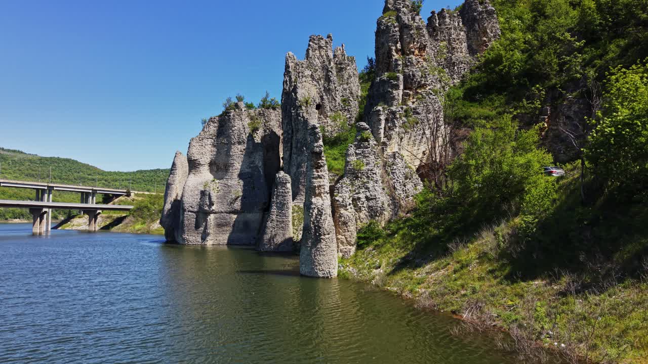 Felsformationen und Wasser unter klarem Himmel in einer ländlichen Gegend.
