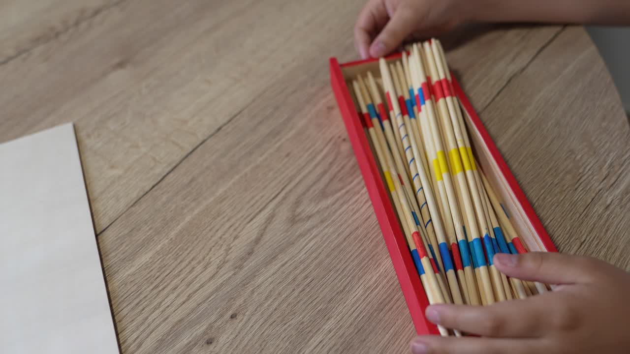 Mikado på et træbord med barn og mor