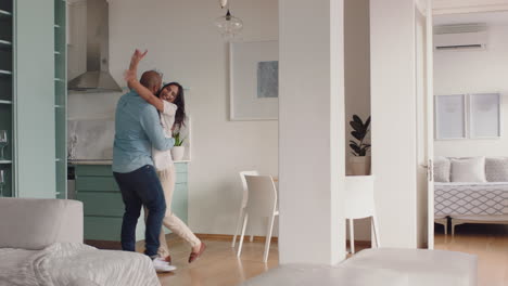 una joven pareja feliz bailando en casa disfrutando de un baile divertido divirtiéndose celebrando