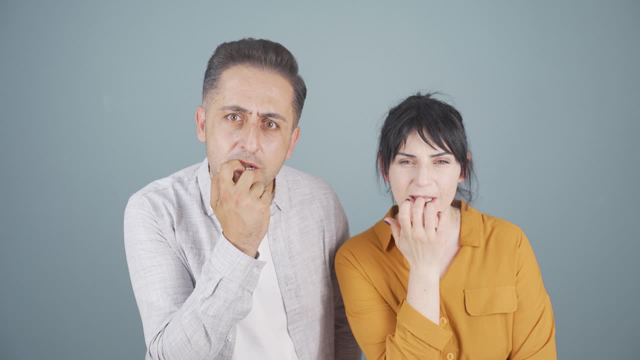 커플이 카메라를 향해 스트레스를 받고 손 ⁇ 을  ⁇ 고 있습니다.