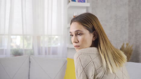 mujer pensativa sentada en casa.