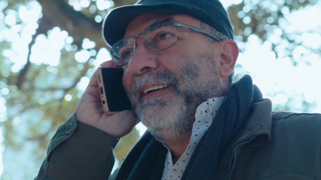 Senior Man Walking in the Park and Talking on the Phone