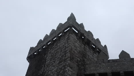 ancient stone castle tower against a cloudy sky shot from below in a wide angle