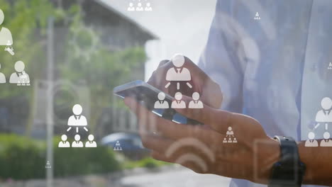 animation of flowcharts and icons over midsection of biracial man scrolling on smartphone
