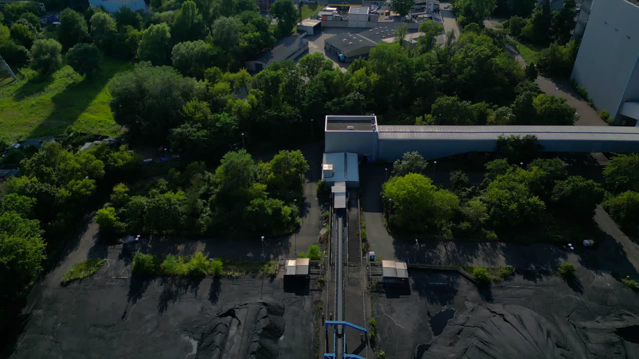 hard coal fired power station transporting coal on conveyor belts, showcasing industrial infrastructure in a city. Best aerial view flight tilt down drone