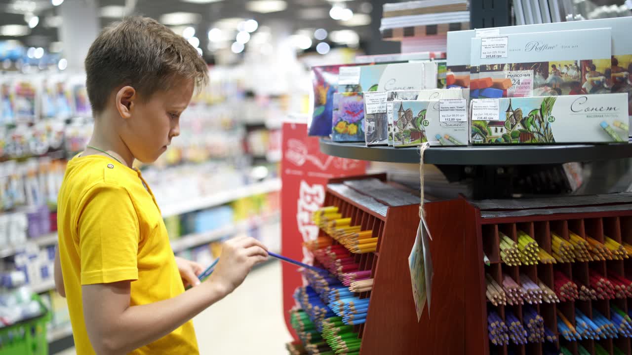 Boy shopping to school. Schoolboy choosing school accessories in store of stationery