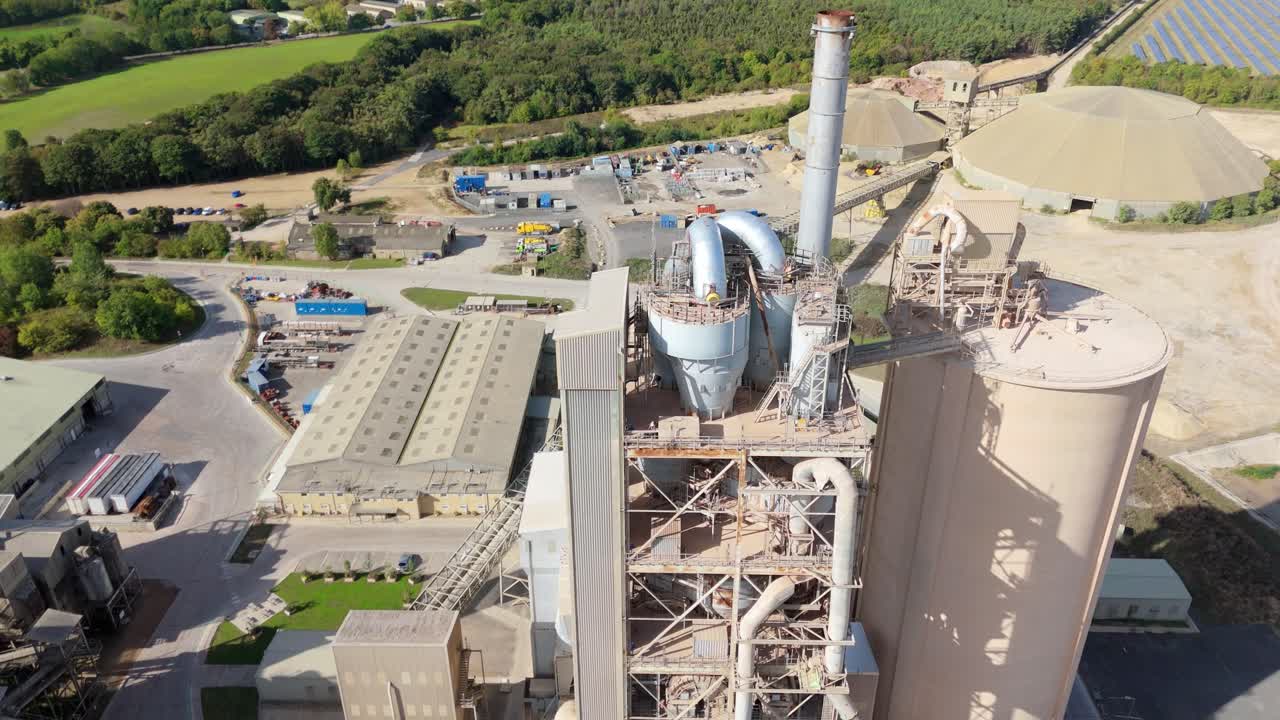 Industrial cement plant with active pipework and aggregates machinery filmed from above near Stamford, United Kingdom
