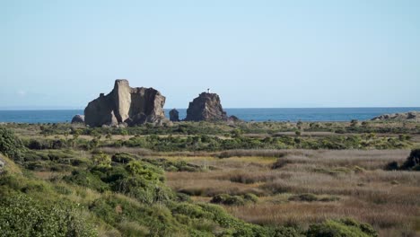 faro y formaciones rocosas en whatipu beach, nueva zelanda