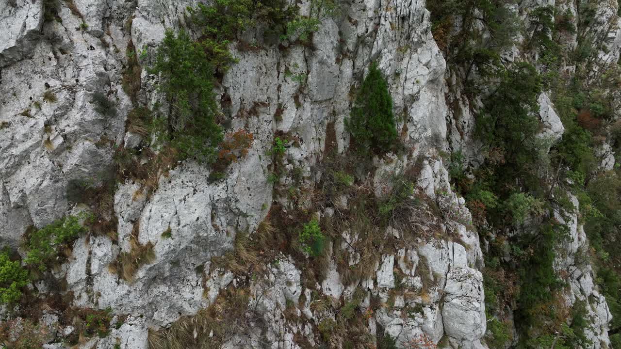 Aerial: rocky mountains with greenery at Lake Koman during the day on the Drin River in Kukes, Shkoder County, northern Albania, pan drone shot