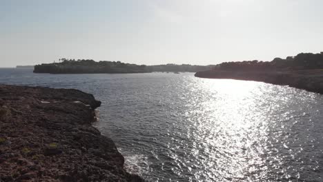 Aéreo:-Volar-Cerca-De-Los-árboles-Y-La-Costa-Para-Obtener-Unas-Magníficas-Vistas-Al-Mar-De-Mallorca