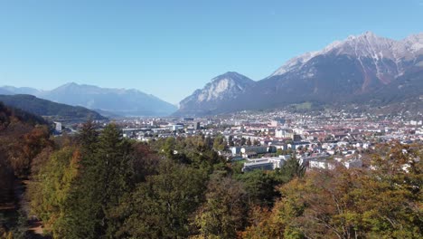 vista aérea del castillo de ambras que muestra los alpes en un soleado día de otoño, con bosques tranquilos, colinas verdes, la ciudad de innsbruck, tirol, austria, europa