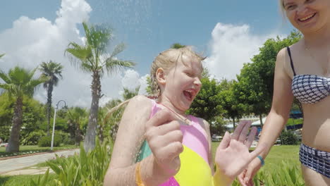 A-Young-Mother-With-Her-Little-Daughter-Is-Having-A-Fun-Shower-By-The-Pool-In-The-Seaside-Resort