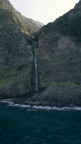 Erleben-Sie-Die-Vertikale-Perspektive-Des-Wasserfalls-Véu-Da-Noiva-Auf-Madeira-Durch-Drohnenaufnahmen-Und-Fangen-Sie-Das-Sonnenlicht-Zwischen-Berggipfeln-Und-Dem-Weiten-Meer-Ein