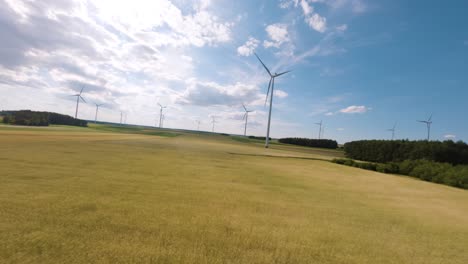 Wind-turbine-farm-and-sunny-warm-day,-aerial-FPV-view