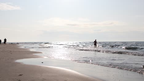 Eine-Frau-Im-Badeanzug,-Die-Spaß-An-Der-Randseite-Der-Wasserwelle-Am-Strand-Hat