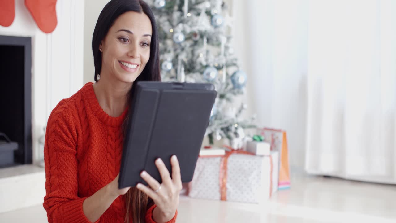 una mujer sonriente informándose en sus redes sociales.
