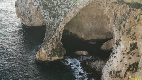 blue grotto sea caves being washed with waves of cold mediterranean sea water