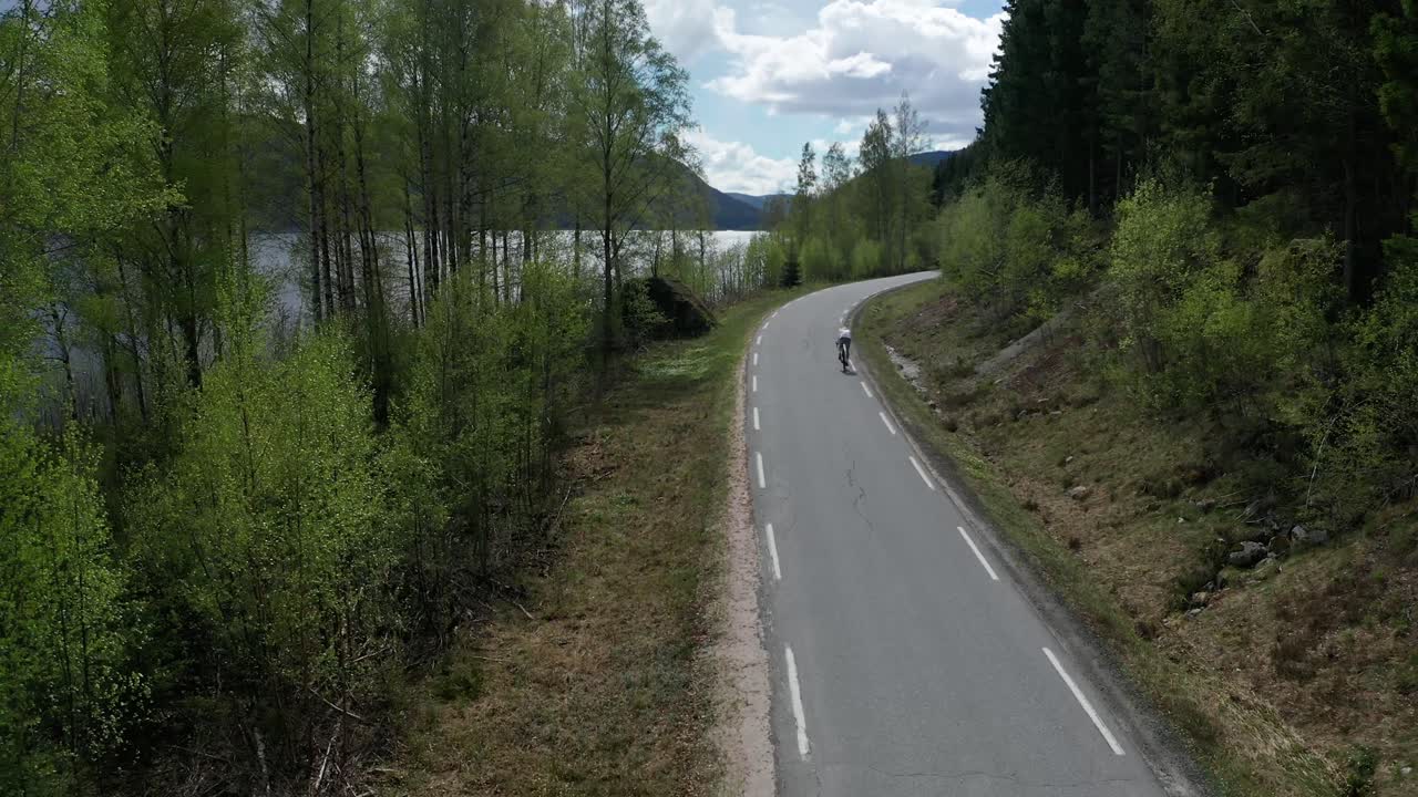 Ciclista su strada che pedala nella splendida natura in Norvegia.