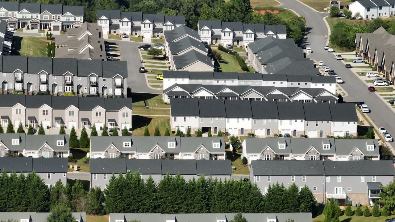 Row of modern two-story houses in modern design. Sunny day in suburb district of American town. Aerial view. Similar houses along road in summer. Virginia, USA