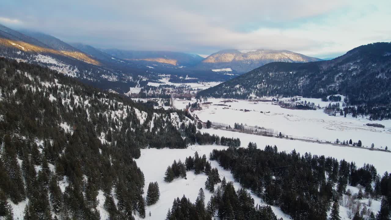 el valle de las malvinas de la región de thompson-nicola en la hora dorada: montañas nevadas y bosques en medio de cielos nublados