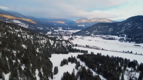 the thompson-nicola region's falkland valley in golden hour: snowy mountains and forests amidst cloudy skies