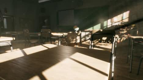 view to classroom with tables and small blackboard and grungy walls