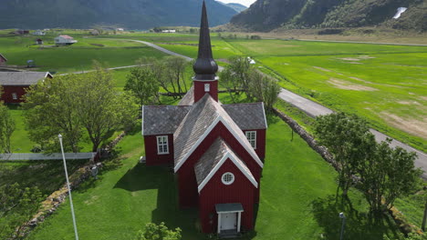 Wunderbare-Luftaufnahme-Im-Orbit-über-Der-Wunderschönen-Flakstad-Kirche-Auf-Den-Lofoten-Inseln-An-Einem-Frühlingstag